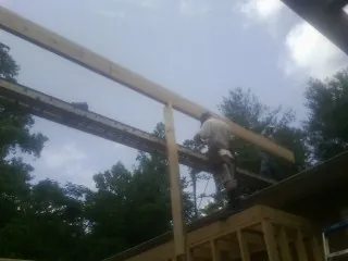 Carpenter setting a ridge beam over a new addition frame — Ice Dam Removal by Roofing Brothers in Bentleyville