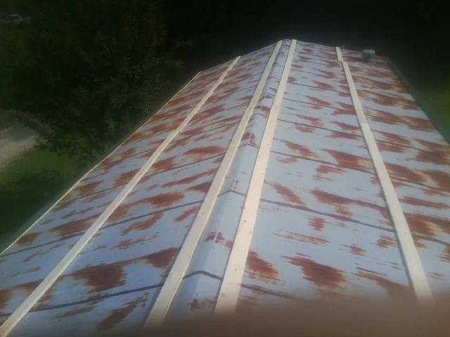 Rusted metal roof panels with new wood purlins before replacement — Storm Damage Roof Repair in Bentleyville by Roofing Brothers