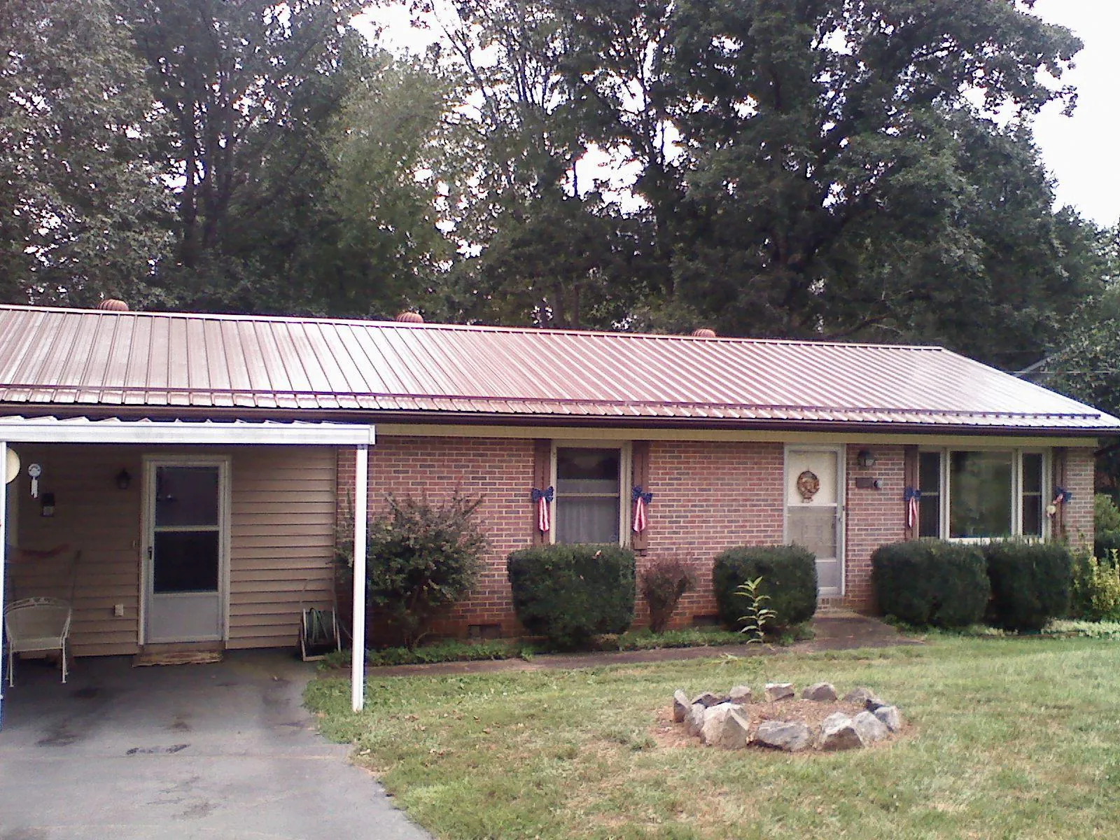 Bronze metal roof and carport on a brick ranch home — Roof Repair work by our crew in Bentleyville